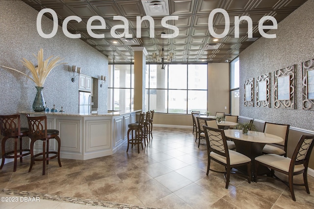 dining space featuring an ornate ceiling, wallpapered walls, and baseboards