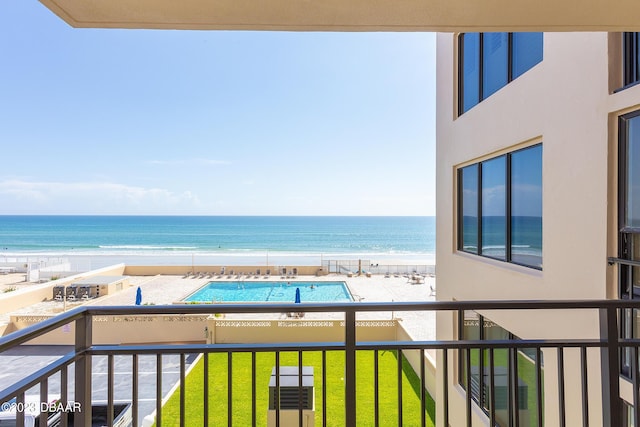 balcony featuring a view of the beach and a water view