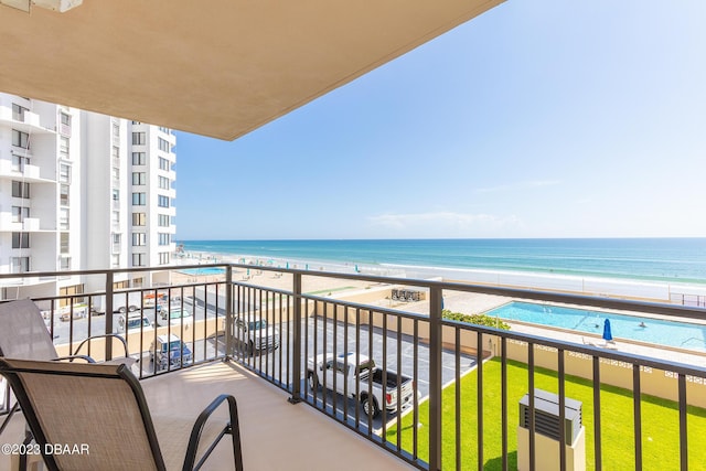 balcony featuring a water view and a beach view