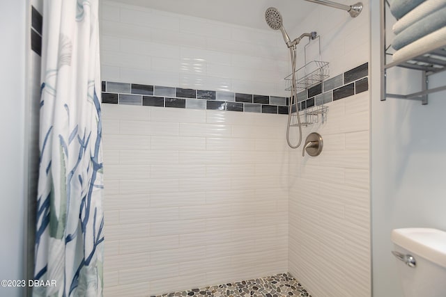 full bath featuring toilet and a tile shower