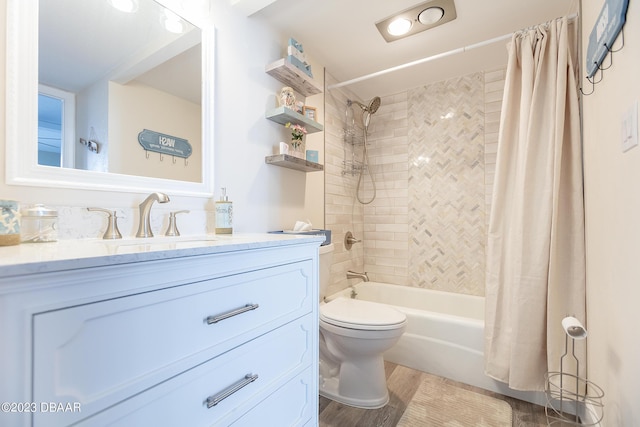 bathroom featuring toilet, wood finished floors, vanity, and shower / bath combination with curtain