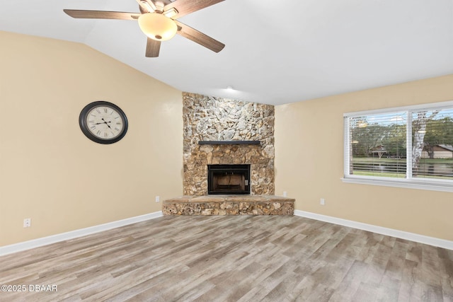 unfurnished living room featuring vaulted ceiling, ceiling fan, a fireplace, and light hardwood / wood-style flooring