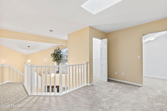 unfurnished room with a skylight and light colored carpet