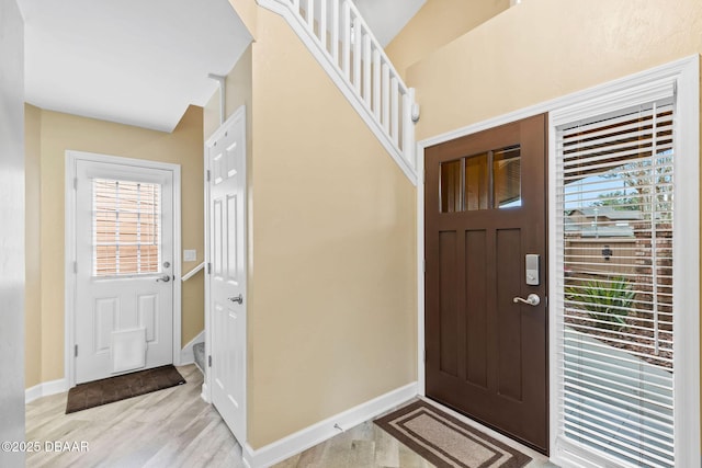 foyer entrance with a wealth of natural light and light hardwood / wood-style flooring