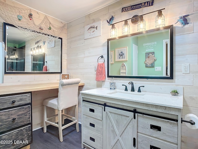 bathroom featuring hardwood / wood-style flooring, vanity, and wooden walls