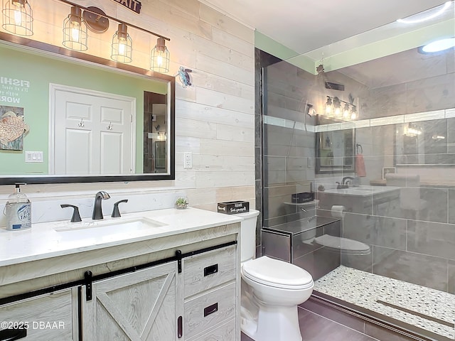 bathroom with an enclosed shower, vanity, tile patterned flooring, toilet, and wood walls