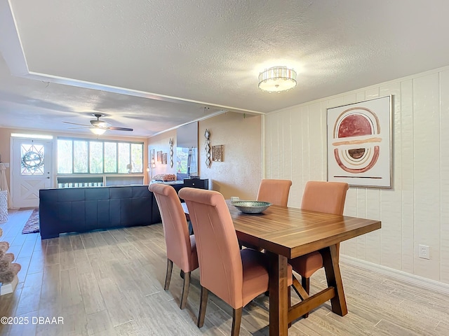 dining area with ceiling fan, a textured ceiling, and hardwood / wood-style flooring