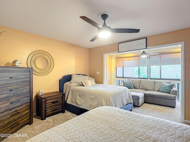 bedroom featuring ceiling fan, light colored carpet, and a textured ceiling