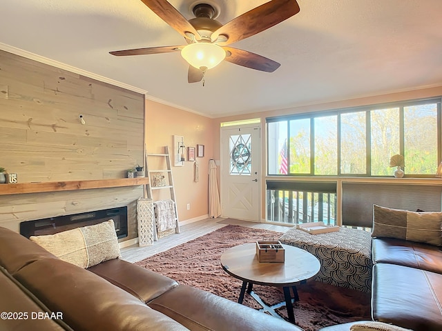 living room featuring light wood-type flooring, ceiling fan, and crown molding