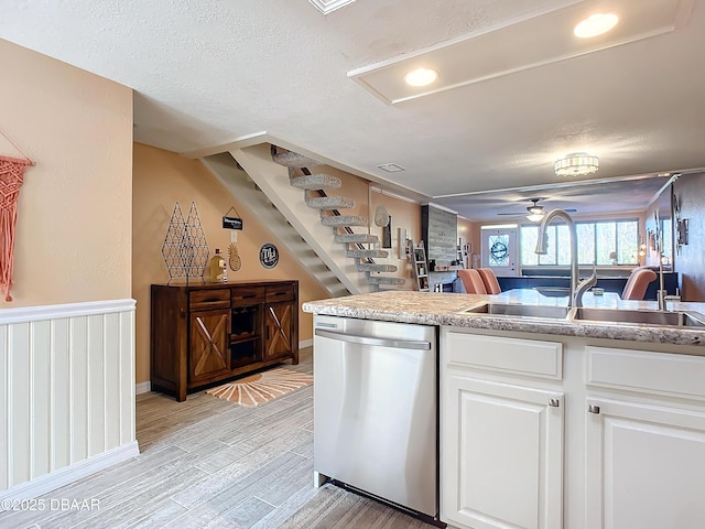 kitchen with ceiling fan, sink, light hardwood / wood-style flooring, dishwasher, and white cabinetry