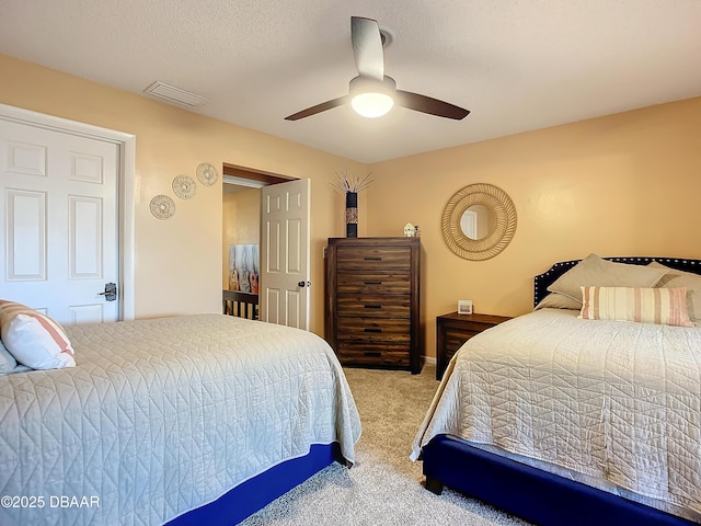 carpeted bedroom with a textured ceiling and ceiling fan