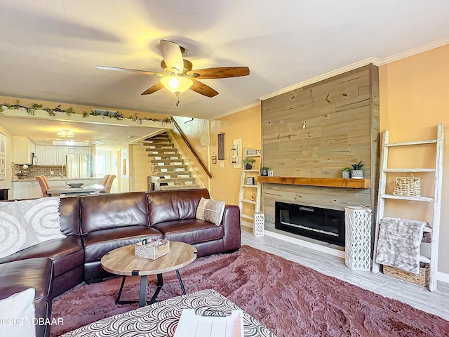 living room with ceiling fan, ornamental molding, and a fireplace