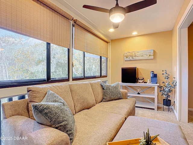 carpeted living room featuring ceiling fan and a wealth of natural light