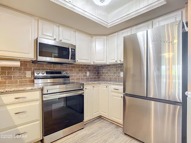 kitchen featuring light stone counters, white cabinetry, and appliances with stainless steel finishes