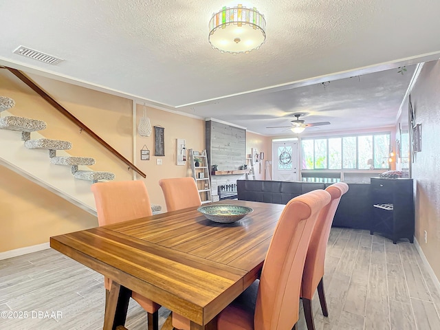 dining room featuring ceiling fan, wood-type flooring, and a textured ceiling