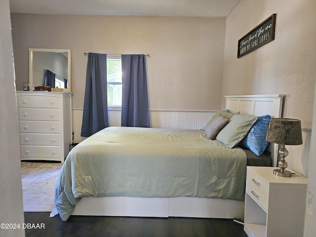 bedroom featuring wainscoting and wood finished floors