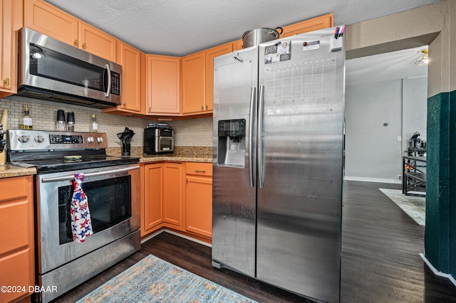 kitchen with light stone counters, appliances with stainless steel finishes, dark wood-type flooring, a textured ceiling, and backsplash