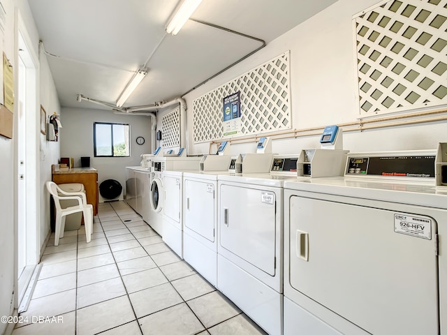 laundry area with washer and dryer and light tile patterned floors