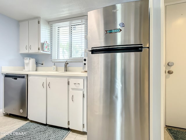 kitchen featuring white cabinets, light tile patterned flooring, and appliances with stainless steel finishes