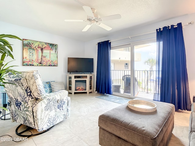 living room with ceiling fan and a textured ceiling