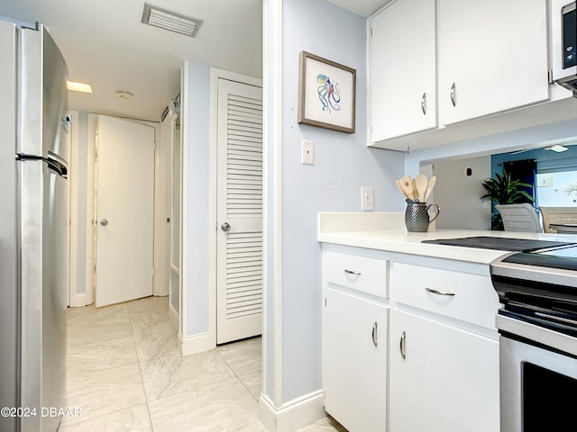 kitchen with white cabinetry and appliances with stainless steel finishes