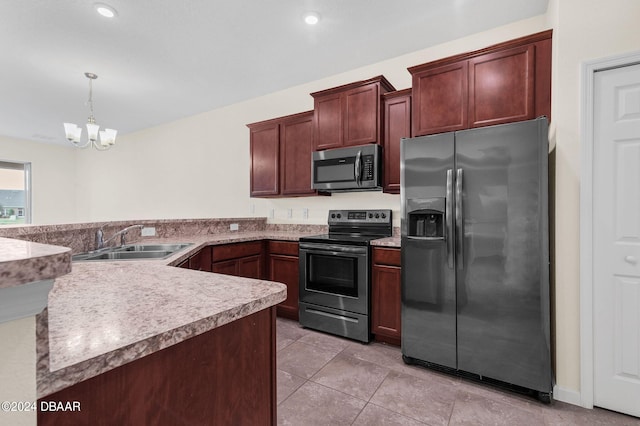 kitchen featuring stainless steel appliances, kitchen peninsula, hanging light fixtures, sink, and a chandelier