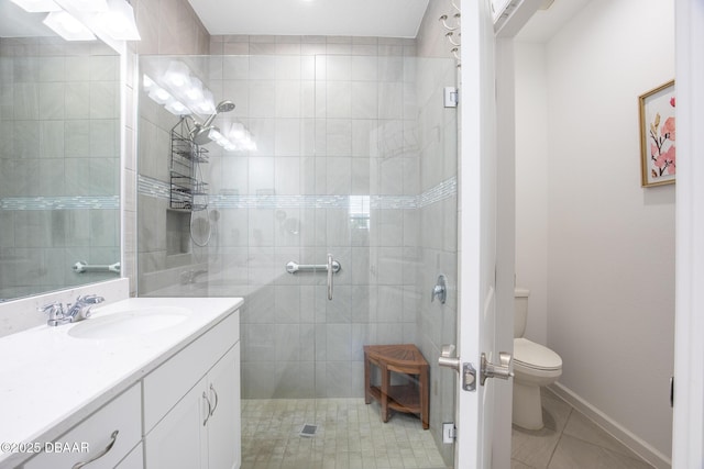 bathroom with a tile shower, vanity, tile patterned floors, and toilet