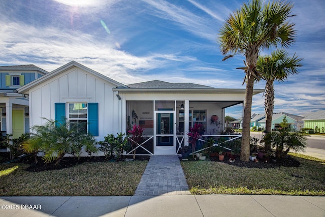 view of front of property featuring a front lawn and a sunroom