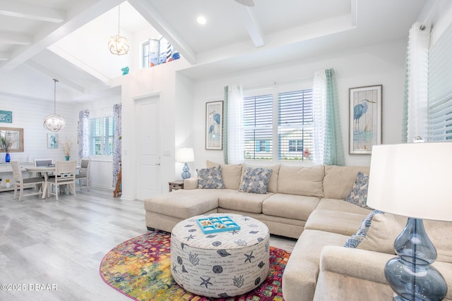 living room with lofted ceiling with beams, a notable chandelier, and light hardwood / wood-style floors