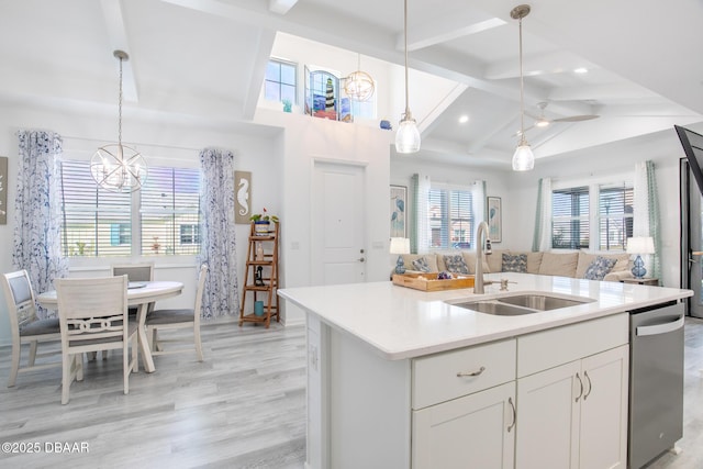 kitchen featuring white cabinetry, sink, hanging light fixtures, and a center island with sink