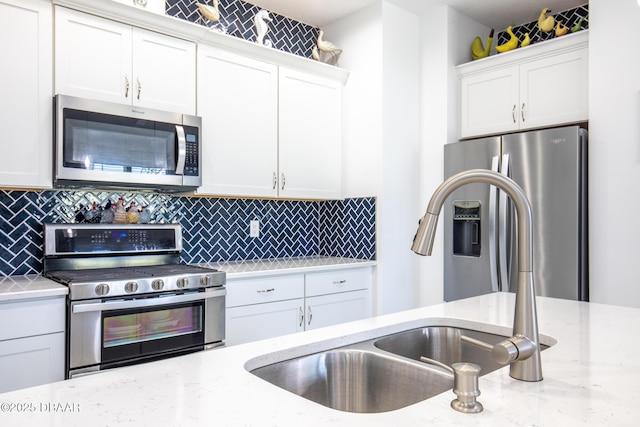 kitchen with appliances with stainless steel finishes, decorative backsplash, and white cabinets