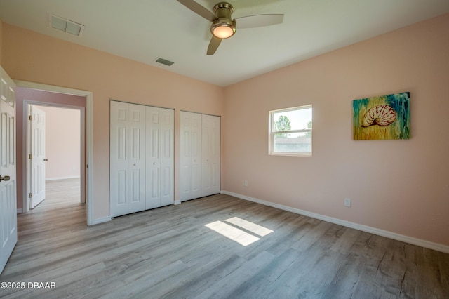 707 Hamilton St, New Smyrna Beach, FL 32168 - unfurnished bedroom with multiple closets, light wood-style floors, baseboards, and a ceiling fan