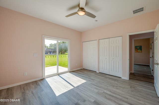 707 Hamilton St, New Smyrna Beach, FL 32168 - unfurnished bedroom with access to exterior, multiple closets, light wood-style flooring, baseboards, and ceiling fan
