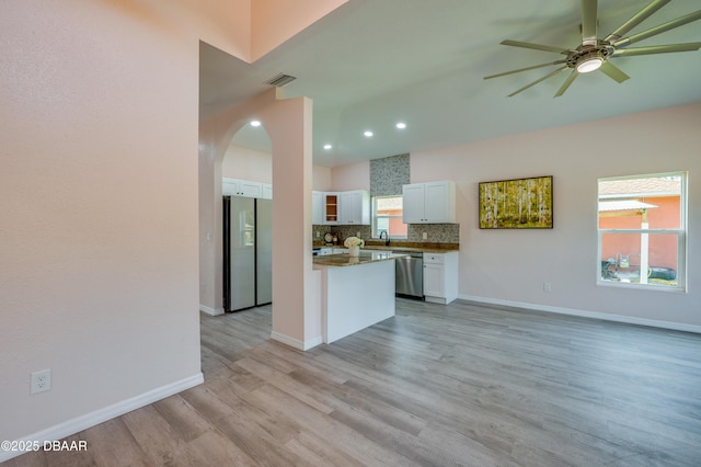 707 Hamilton St, New Smyrna Beach, FL 32168 - kitchen with stainless steel appliances, a sink, white cabinets, a ceiling fan, and dark countertops