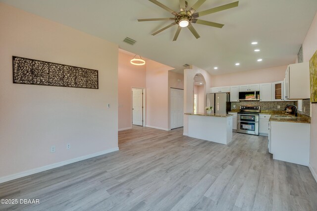 707 Hamilton St, New Smyrna Beach, FL 32168 - kitchen featuring appliances with stainless steel finishes, open floor plan, ceiling fan, white cabinets, and decorative backsplash