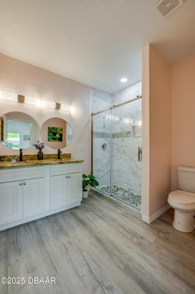 707 Hamilton St, New Smyrna Beach, FL 32168 - bathroom with toilet, wood finished floors, double vanity, a marble finish shower, and recessed lighting