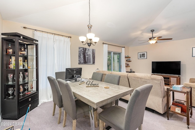 carpeted dining room with vaulted ceiling and ceiling fan with notable chandelier