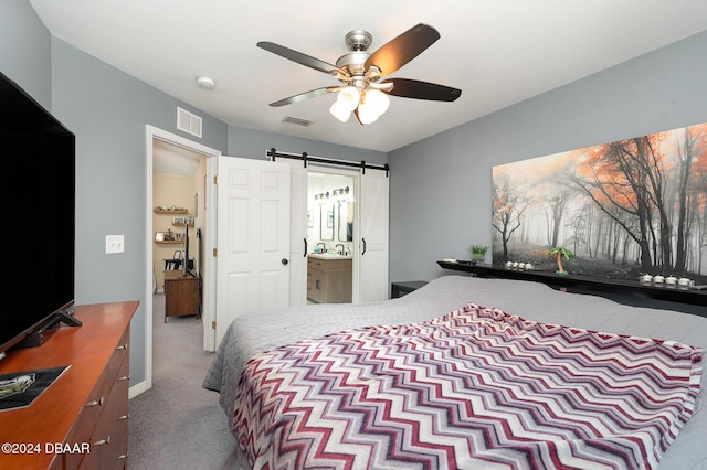 bedroom with carpet flooring, a barn door, and ceiling fan