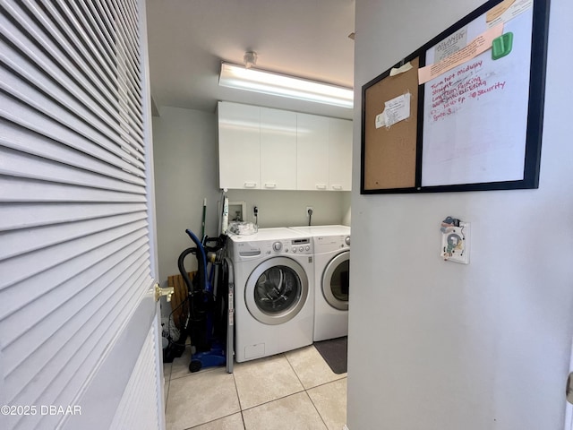 laundry room featuring light tile patterned floors, cabinets, and washer and dryer