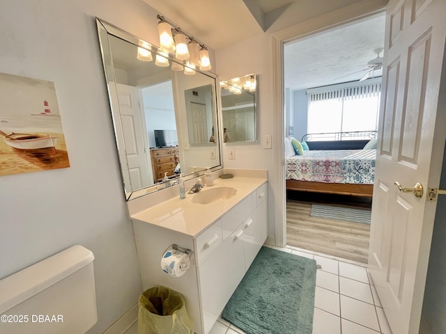 bathroom with ceiling fan, toilet, vanity, and tile patterned flooring