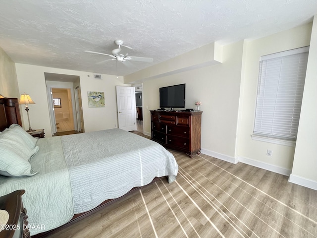 bedroom with hardwood / wood-style flooring, a textured ceiling, and ceiling fan