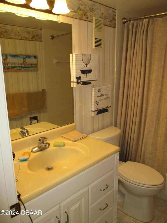 bathroom with toilet, vanity, tile patterned floors, and walk in shower