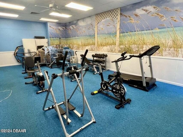 gym featuring ceiling fan and a drop ceiling