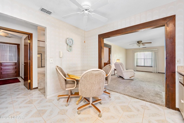 dining area with light colored carpet and ceiling fan