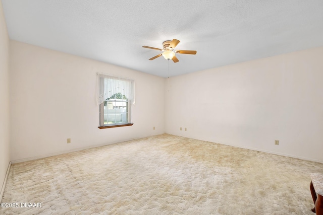 carpeted spare room with ceiling fan and a textured ceiling