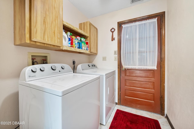 laundry area featuring cabinets, washing machine and dryer, and light tile patterned floors