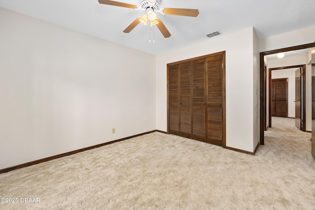 unfurnished bedroom featuring ceiling fan, a closet, and light carpet