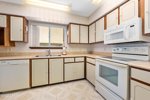 kitchen with white appliances, sink, and light tile patterned floors