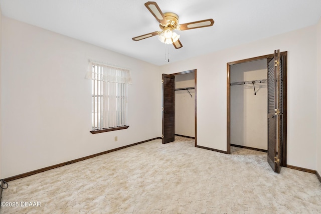 unfurnished bedroom with two closets and ceiling fan