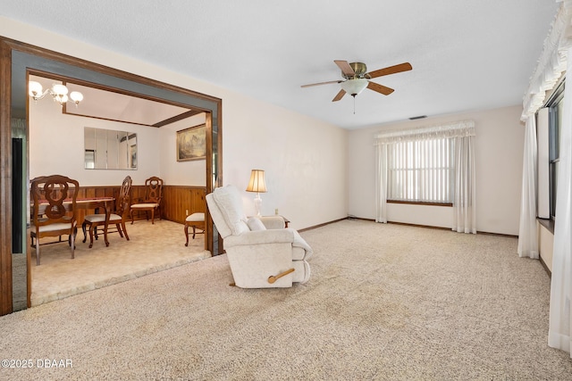 sitting room with carpet flooring and ceiling fan with notable chandelier